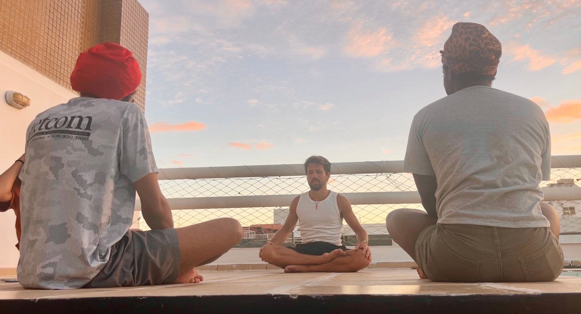 Guests meditating together on the rooftop at sunset
